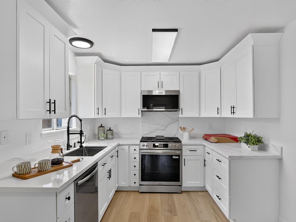 Renovated kitchen with white shaker cabinetry and quartz counters